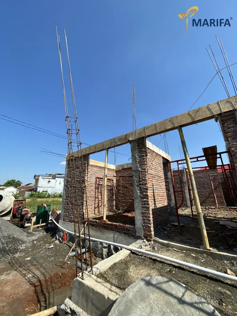 kalkulator dan blueprint rumah di meja kerja
